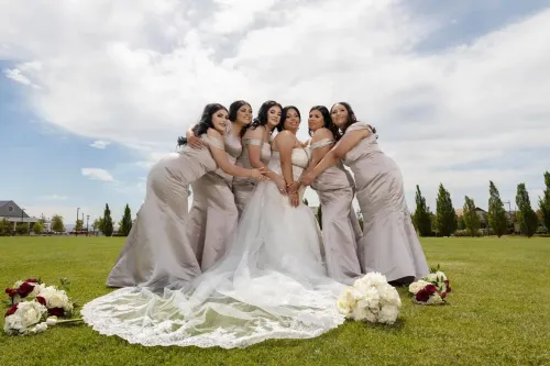 Novia rodeada de damas de honor en un campo abierto. Imagen grupal emotiva de boda por David Sánchez.