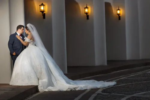 Novios bailando en un elegante salón iluminado con luces cálidas. Fotografía del primer baile de boda por David Sánchez.