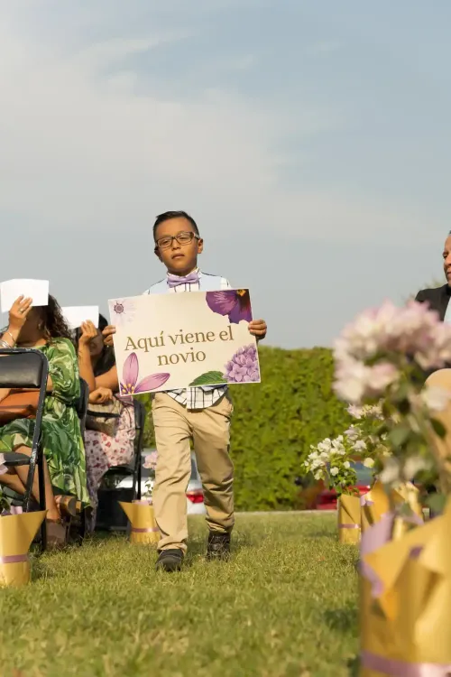 Invitado sosteniendo un cartel con mensaje para los novios. Fotografía espontánea de boda por David Sánchez.