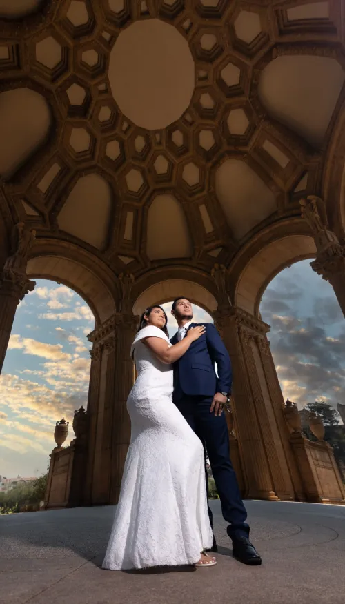 Novios besándose en una estructura arquitectónica impresionante. Imagen artística de boda con composición única por David Sánchez.