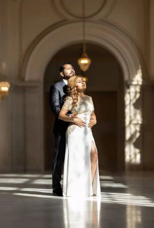 Novios en un lujoso salón con lámparas doradas. Foto de boda clásica y sofisticada por David Sánchez.